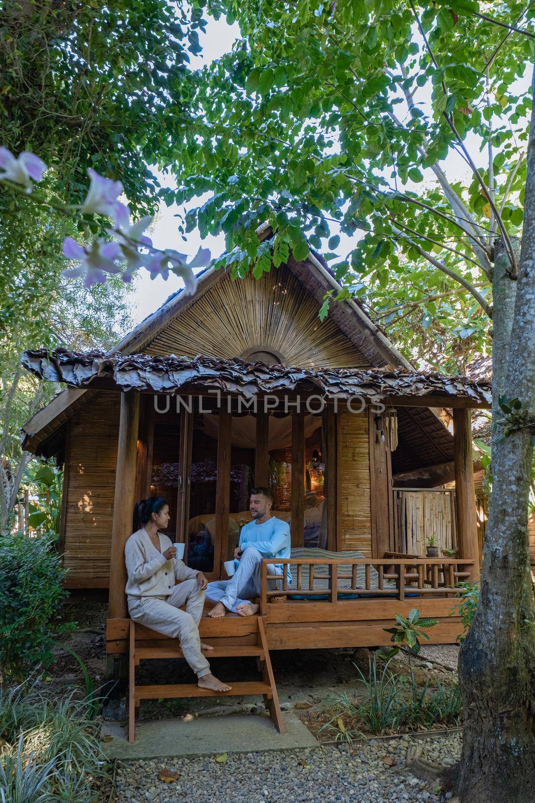 couple man and woman in front of bamboo hut in Northern Thailand by fokkebok