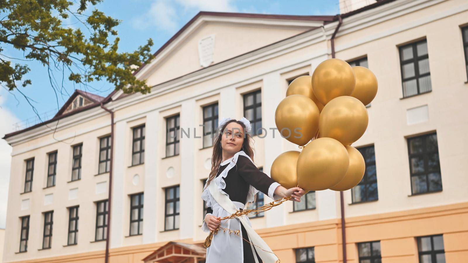 Happy Russian schoolgirl on the last day of school with balloons. by DovidPro