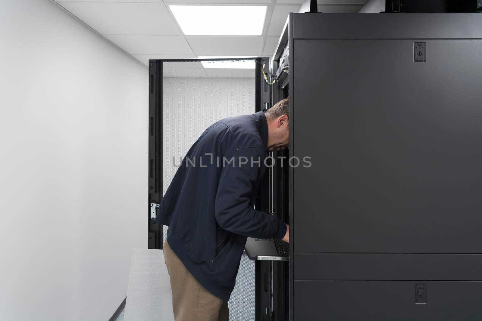 Technicians team updating hardware inspecting system performance in super computer server room or cryptocurrency mining farm. by dotshock