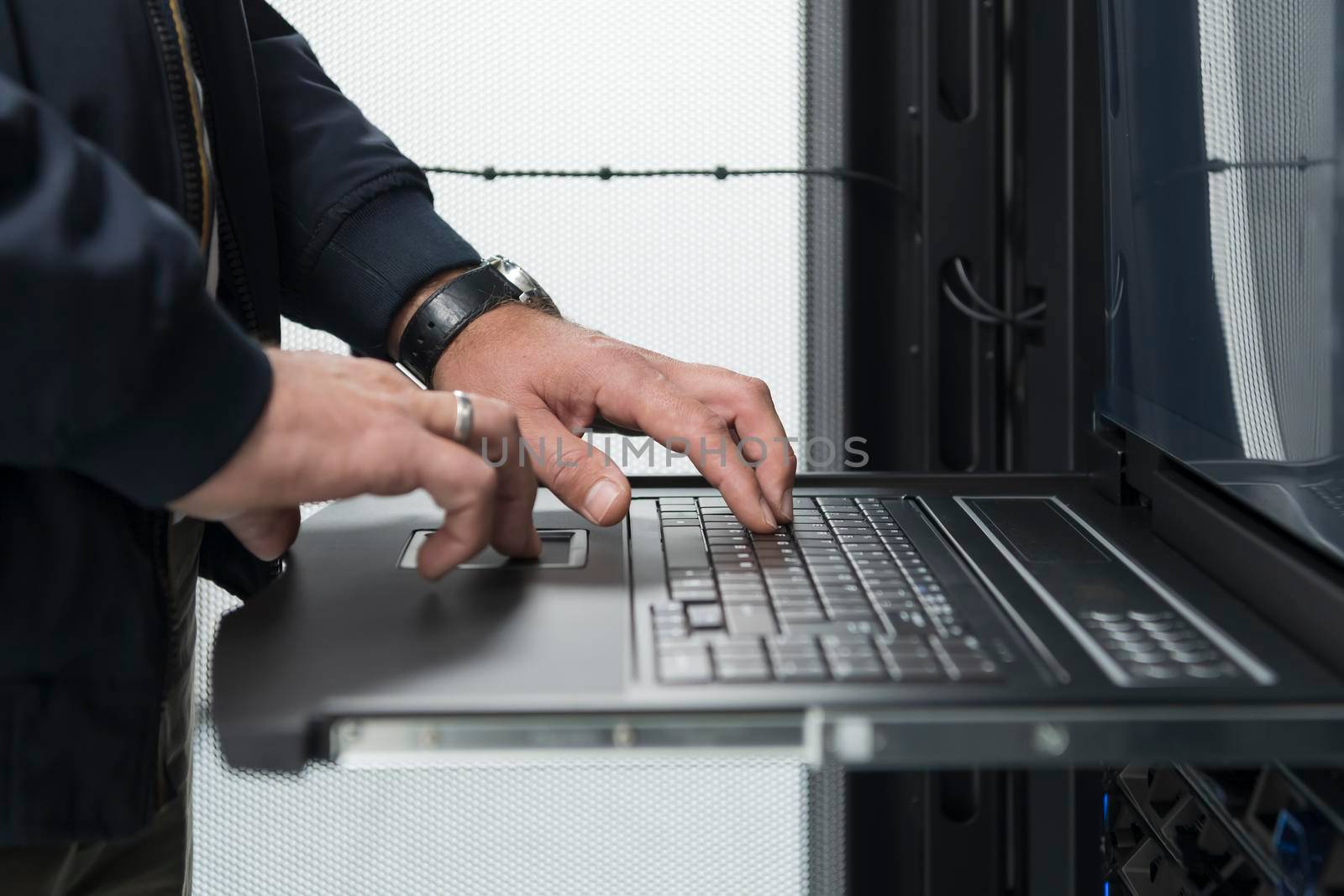 Close up on Data Center Engineer hands Using keyboard on a supercomputer. Server Room Specialist Facility with Male System Administrator Working with Data Protection Network for Cyber Security.