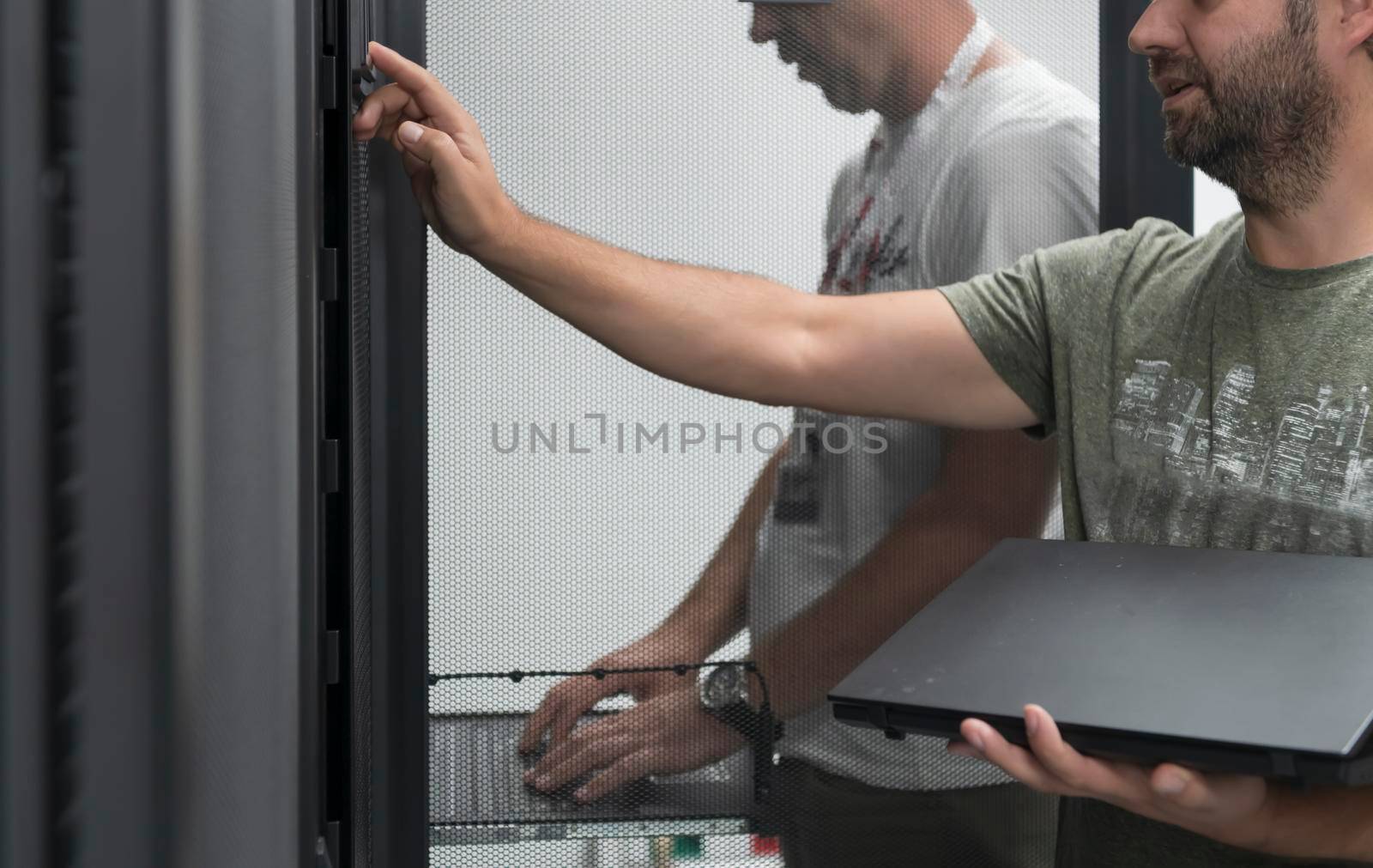 A couple of server engineers cooperate in high tech data centers. Technicians team updating hardware inspecting system performance in super computer server room or cryptocurrency mining farm.