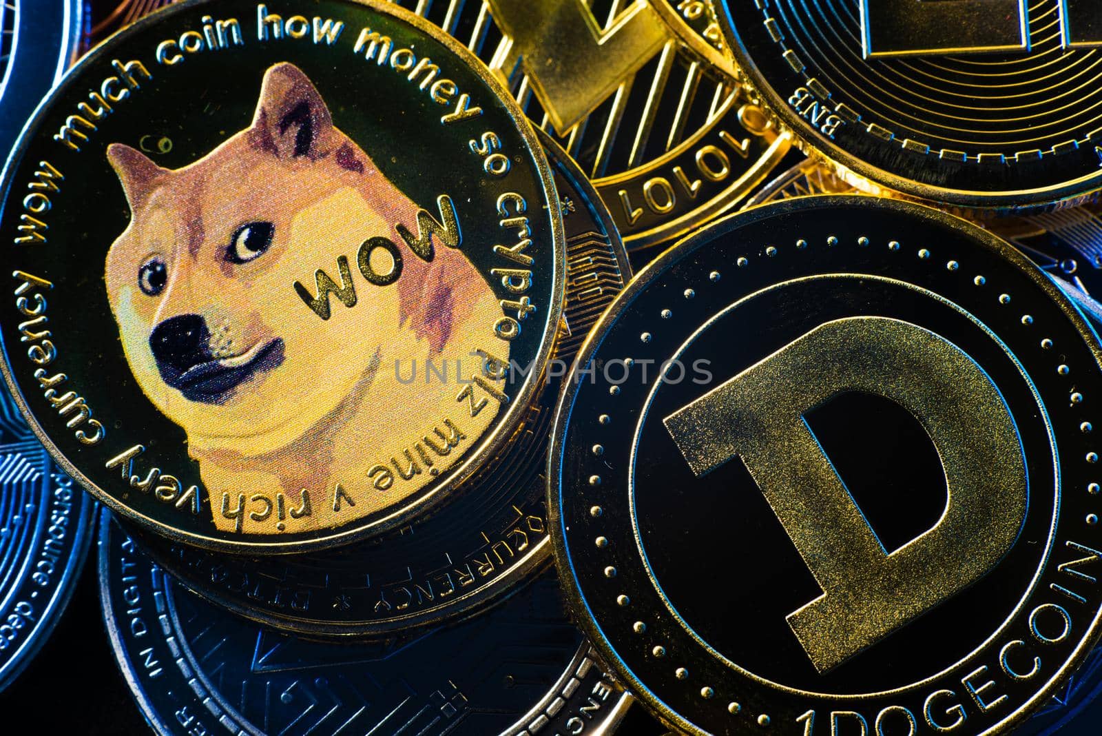 Horizontal view of cryptocurrency tokens, including Bitcoin, dogecoin, and ethererum seen from above on a black background by avirozen