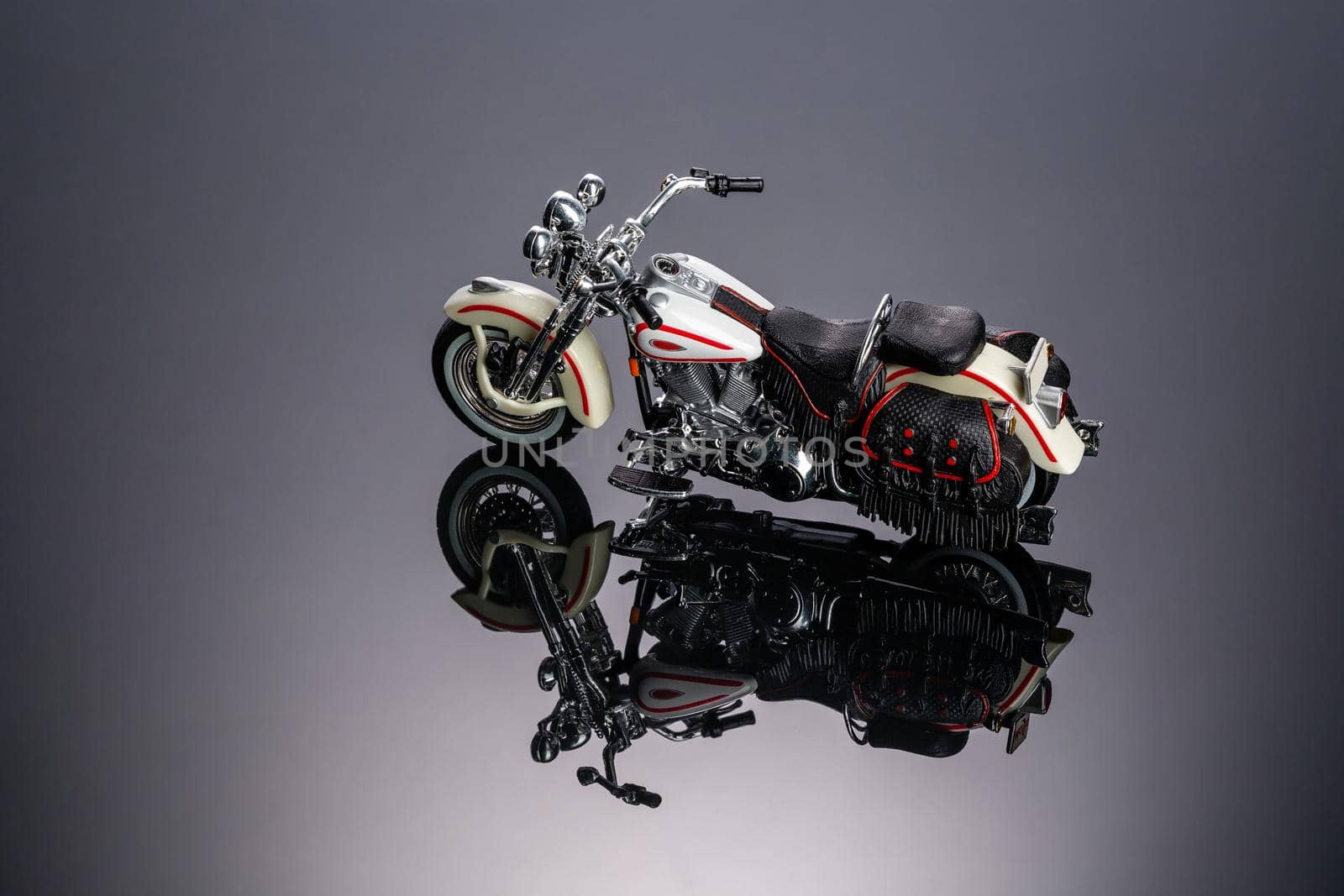 Toy motorcycle on a piece of black acrylic . High quality photo