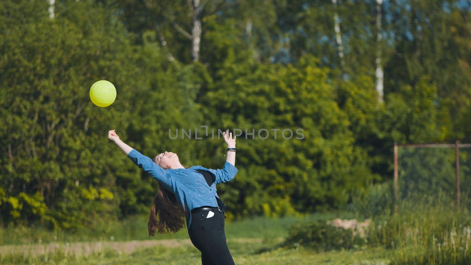 Two girlfriends play volleyball in the meadow