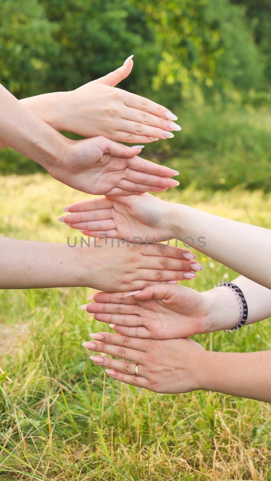 Girlfriends put their palms of their hands on top of each other