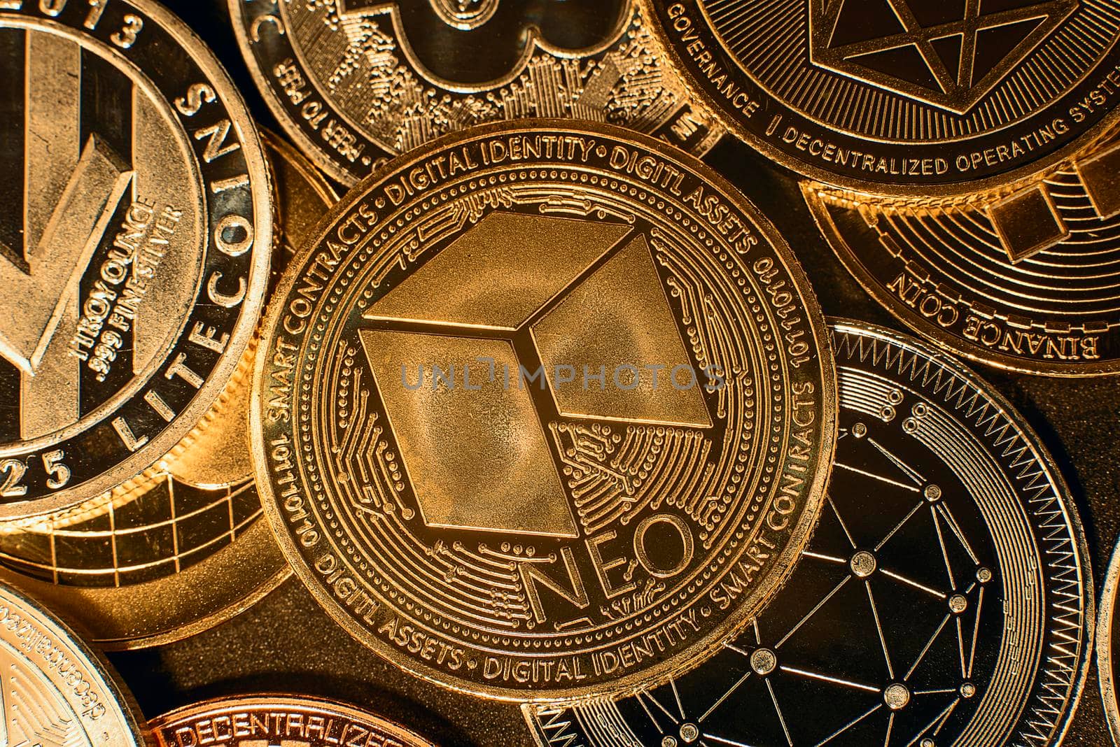 Horizontal view of cryptocurrency tokens, including NEO, Bitcoin, dogecoin, and Ethereum saw from above on a black background. High quality photo