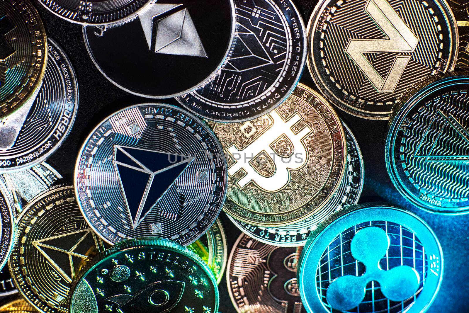 Horizontal view of cryptocurrency tokens, including Bitcoin, dogecoin, and ethererum seen from above on a black background. High quality photo
