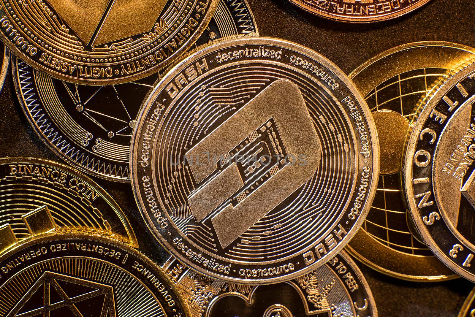 Horizontal view of cryptocurrency tokens, including Dash, Bitcoin, dogecoin, and Ethereum seen from above on a black background. High quality photo