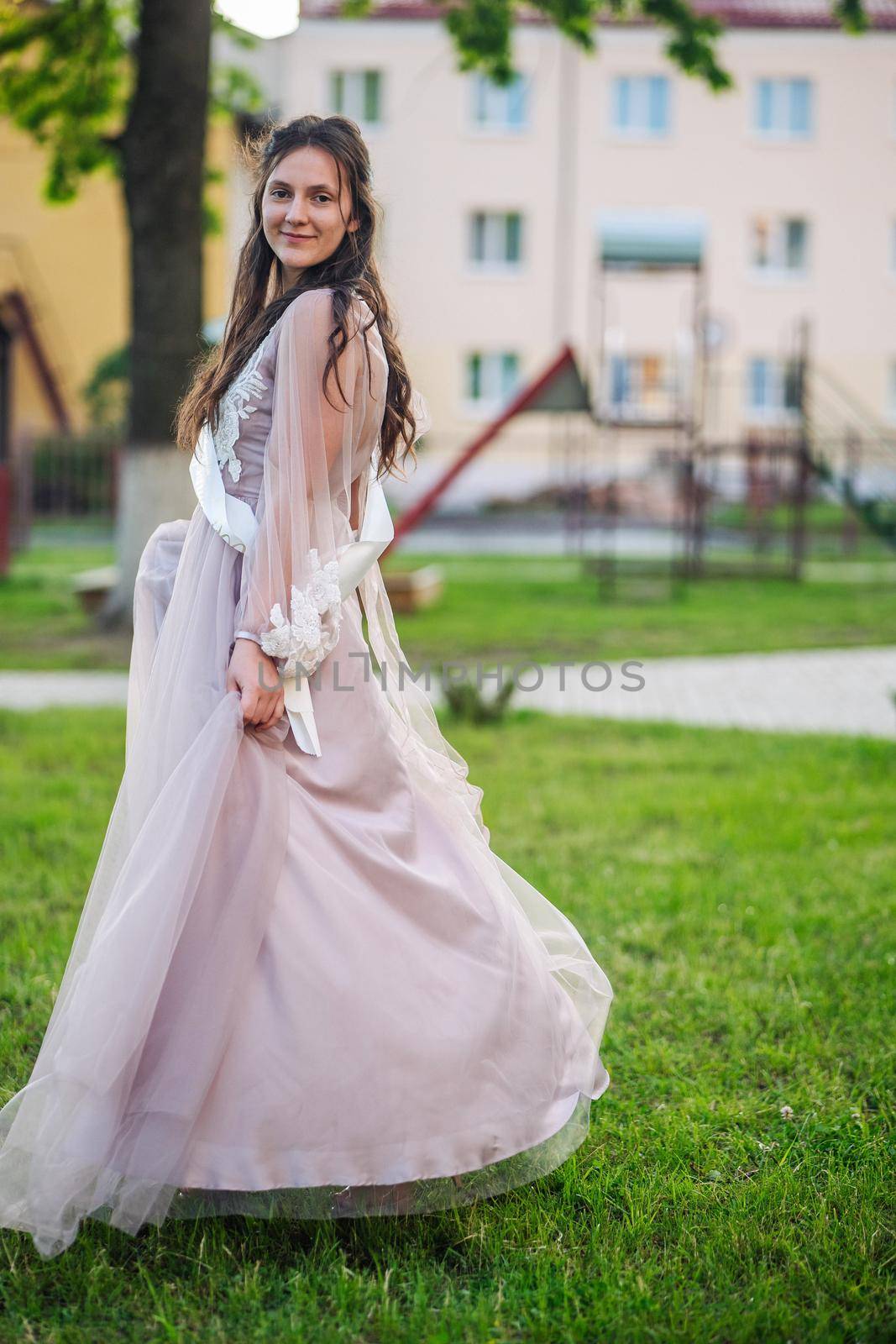 Beautiful schoolgirl in dress at the prom at school