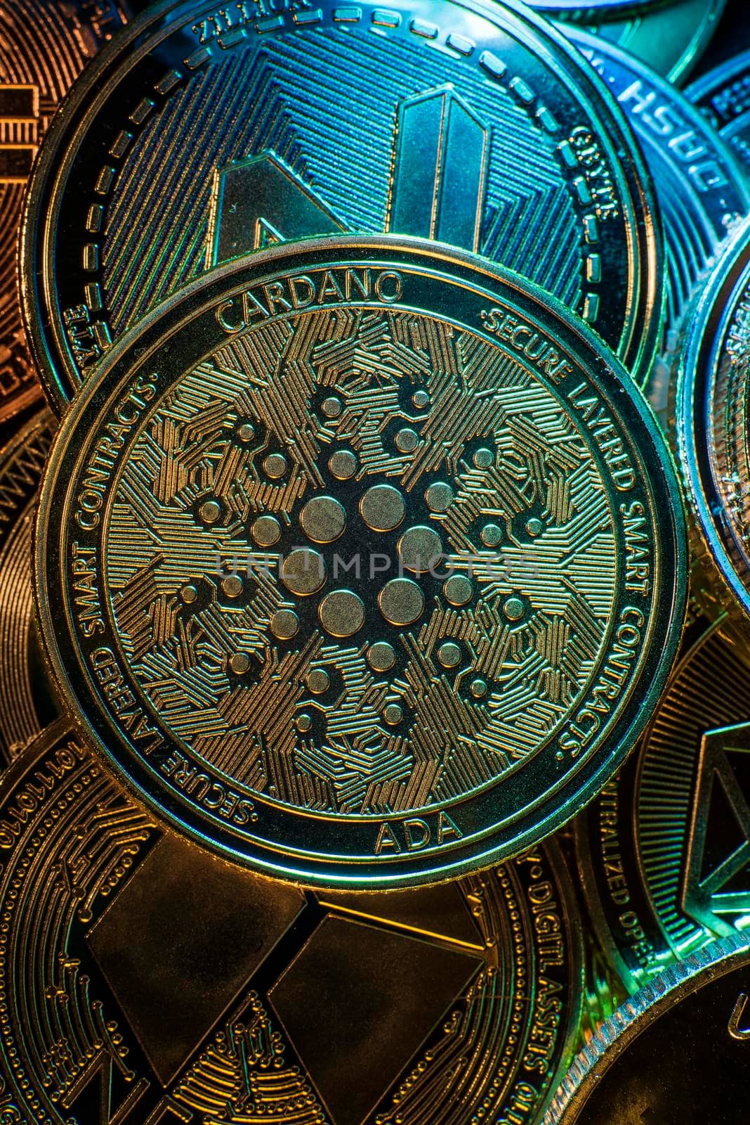 Horizontal view of cryptocurrency tokens, including Cardano, Bitcoin, dogecoin, and Ethereum seen from above on a black background by avirozen