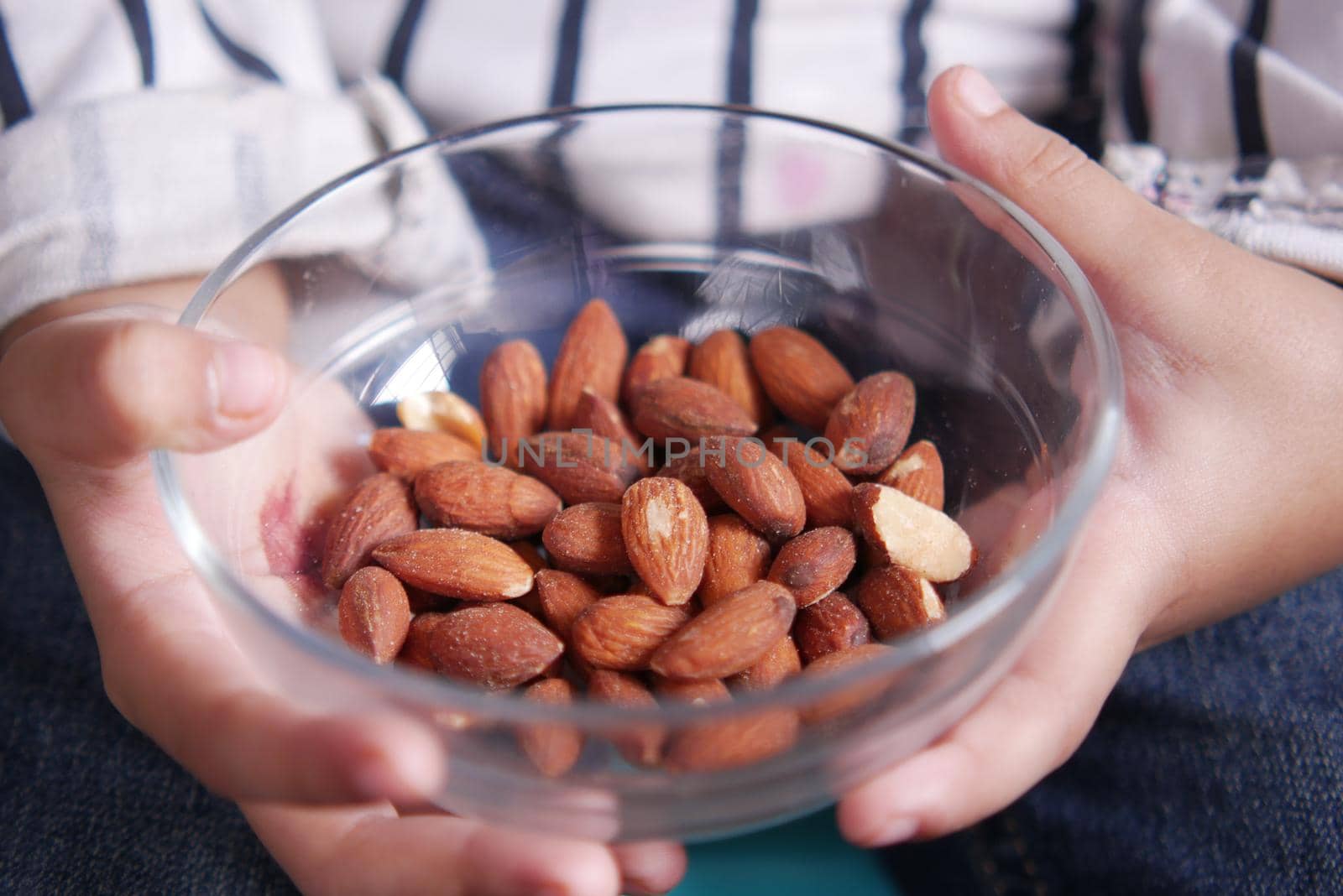 child holding a bowl of almond .