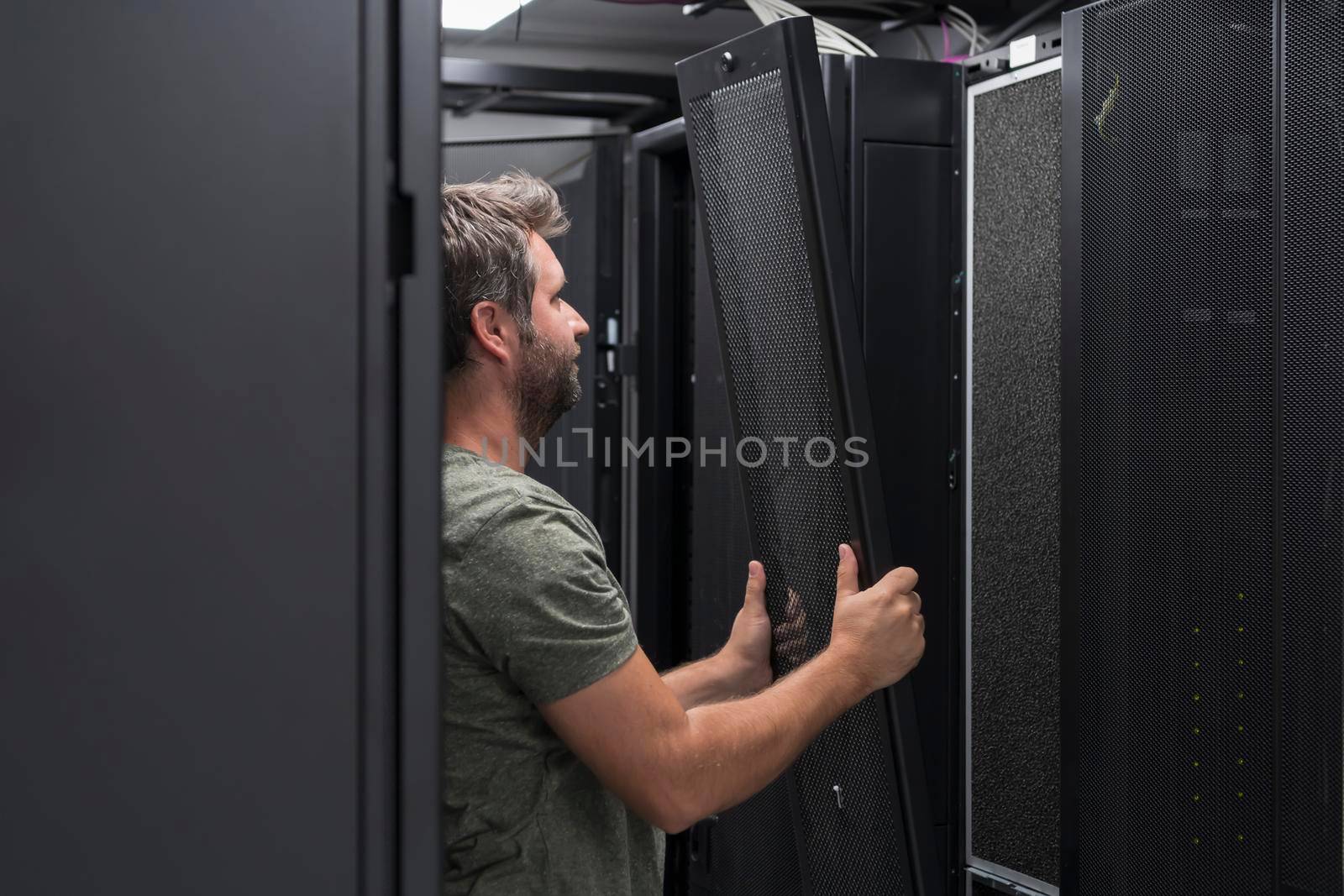 IT engineer working In the server room or data center The technician puts in a rack a new server of corporate business mainframe supercomputer or cryptocurrency mining farm. by dotshock