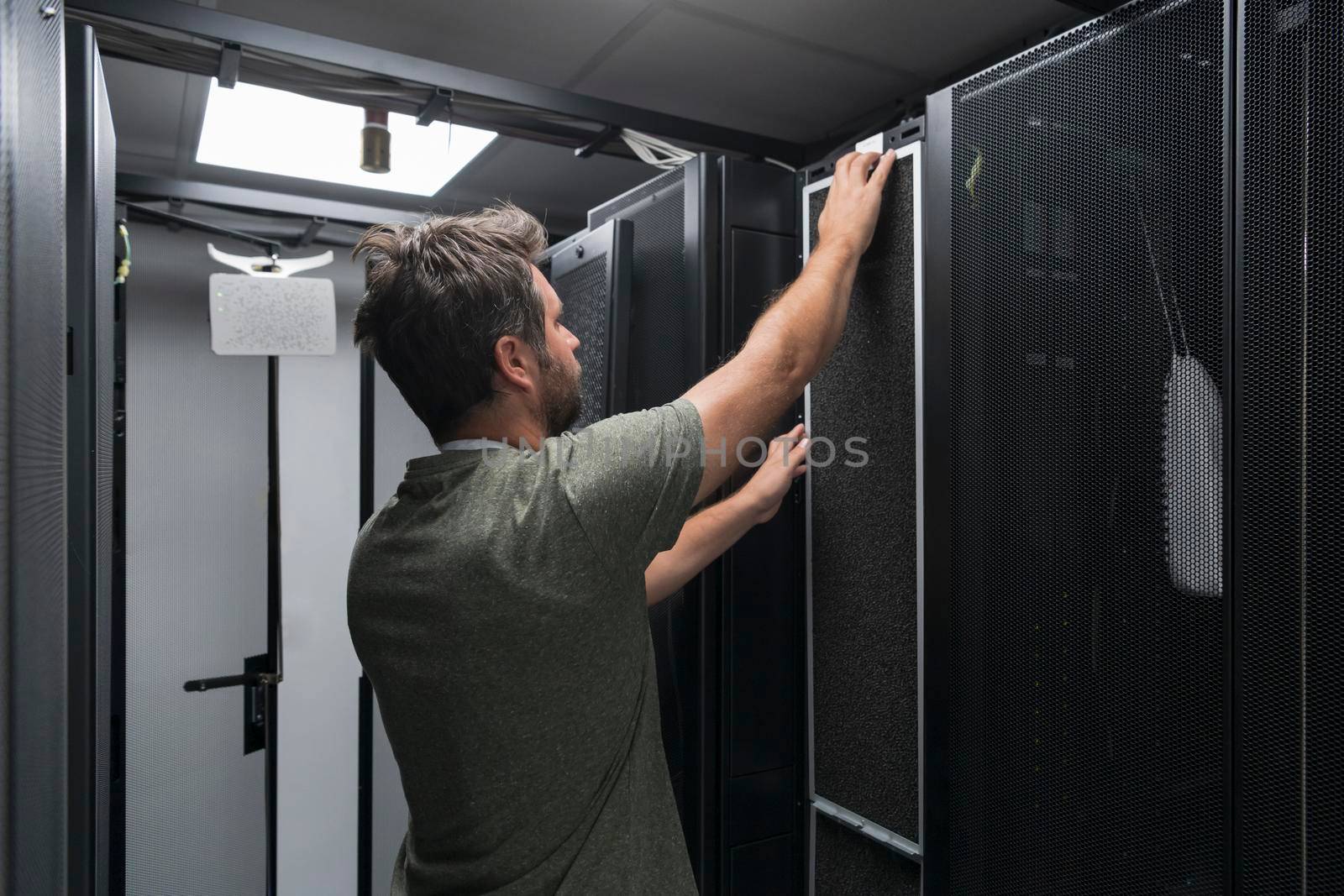 IT engineer working In the server room or data center The technician puts in a rack a new server of corporate business mainframe supercomputer or cryptocurrency mining farm. by dotshock