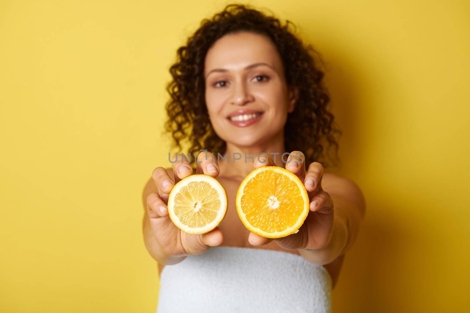 Soft focus on slices of citrus , lemon and orange, in the female hands by artgf