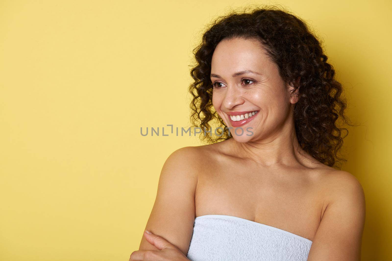 Beauty portrait of a mixed race woman with clean healthy skin on yellow background. by artgf