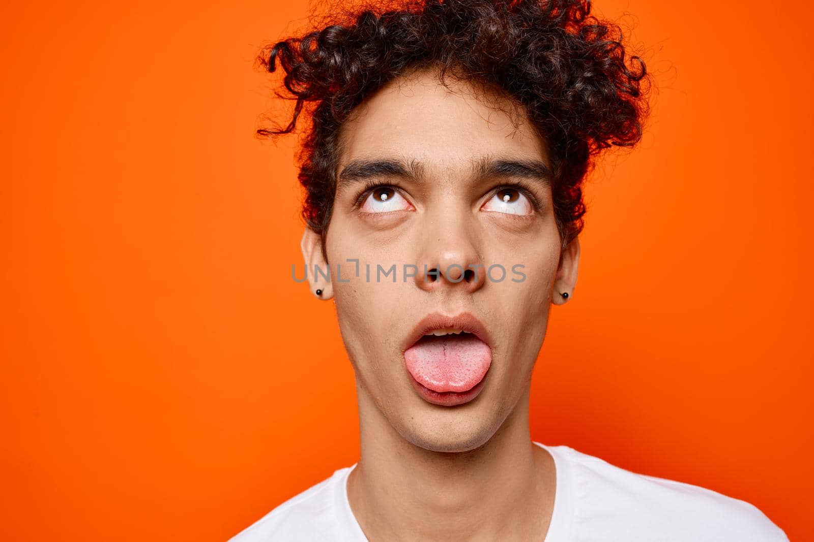 guy with curly hair in a white t-shirt emotions close up. High quality photo