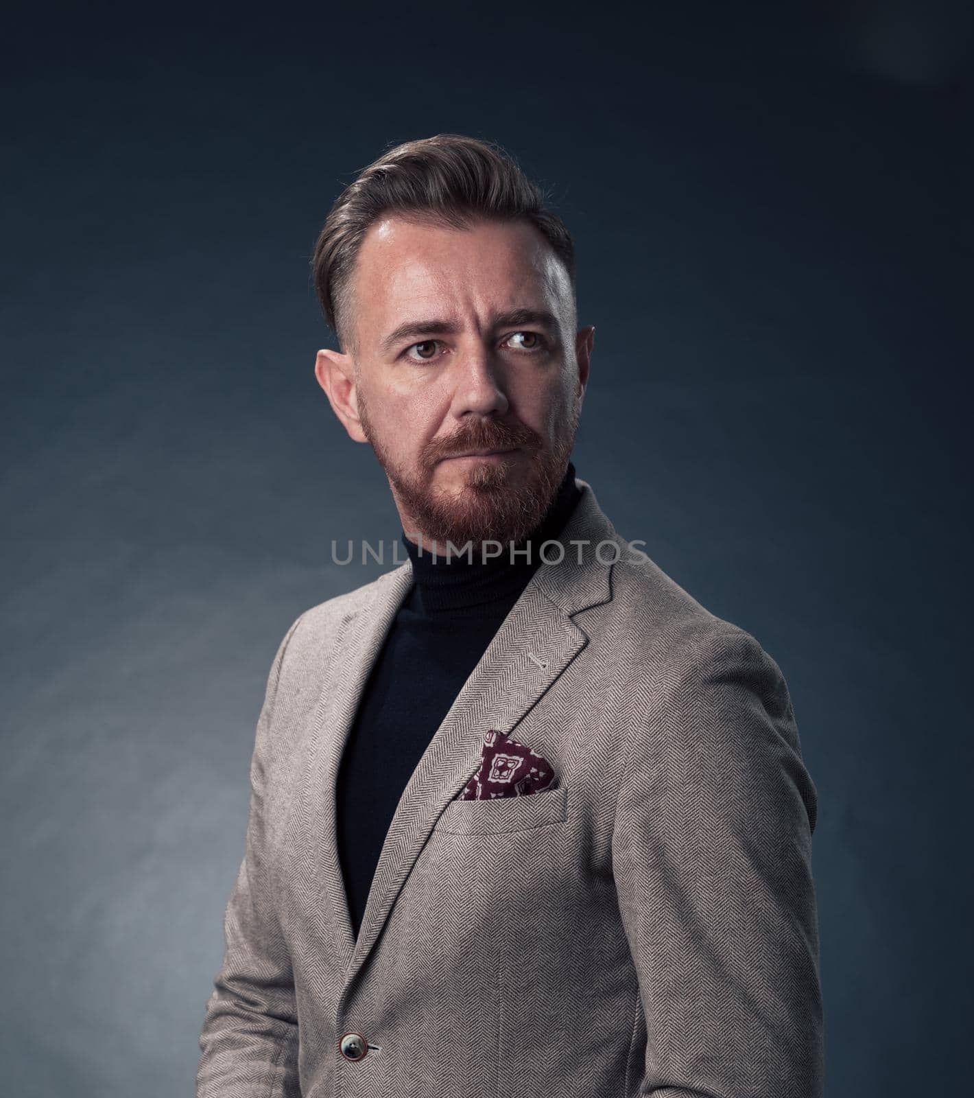 Portrait of a stylish elegant senior businessman with a beard and casual business clothes in photo studio isolated on dark background gesturing with hands by dotshock