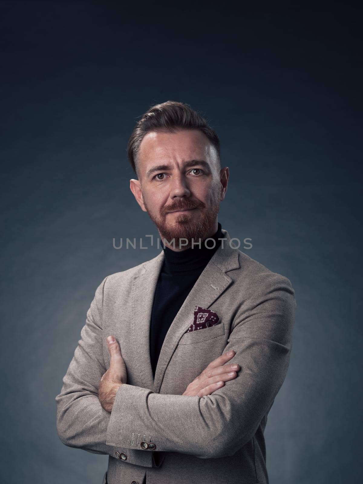 Portrait of a stylish elegant senior businessman with a beard and casual business clothes in photo studio isolated on dark background gesturing with hands by dotshock