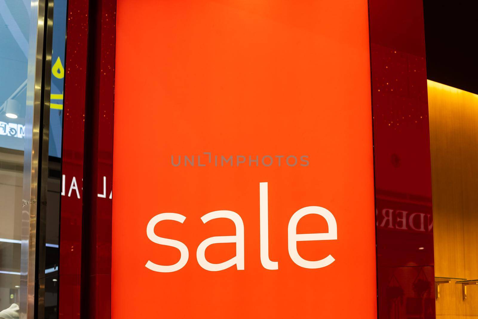 Sale sign at the entrance to clothing store - large red panels with white words.