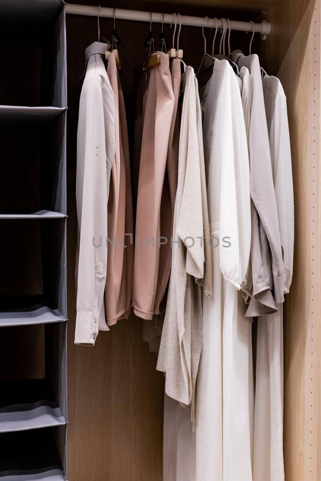 Hangers with different clothes in wardrobe closet