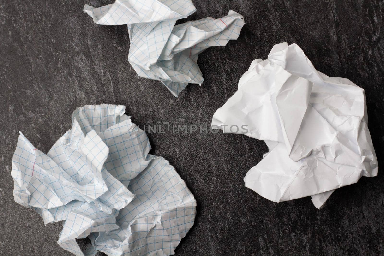 Crumpled and torn paper on the table. Torn piece of notebook. Paper trash. Full basket of notes. Notepad and pencil on crumpled paper background.