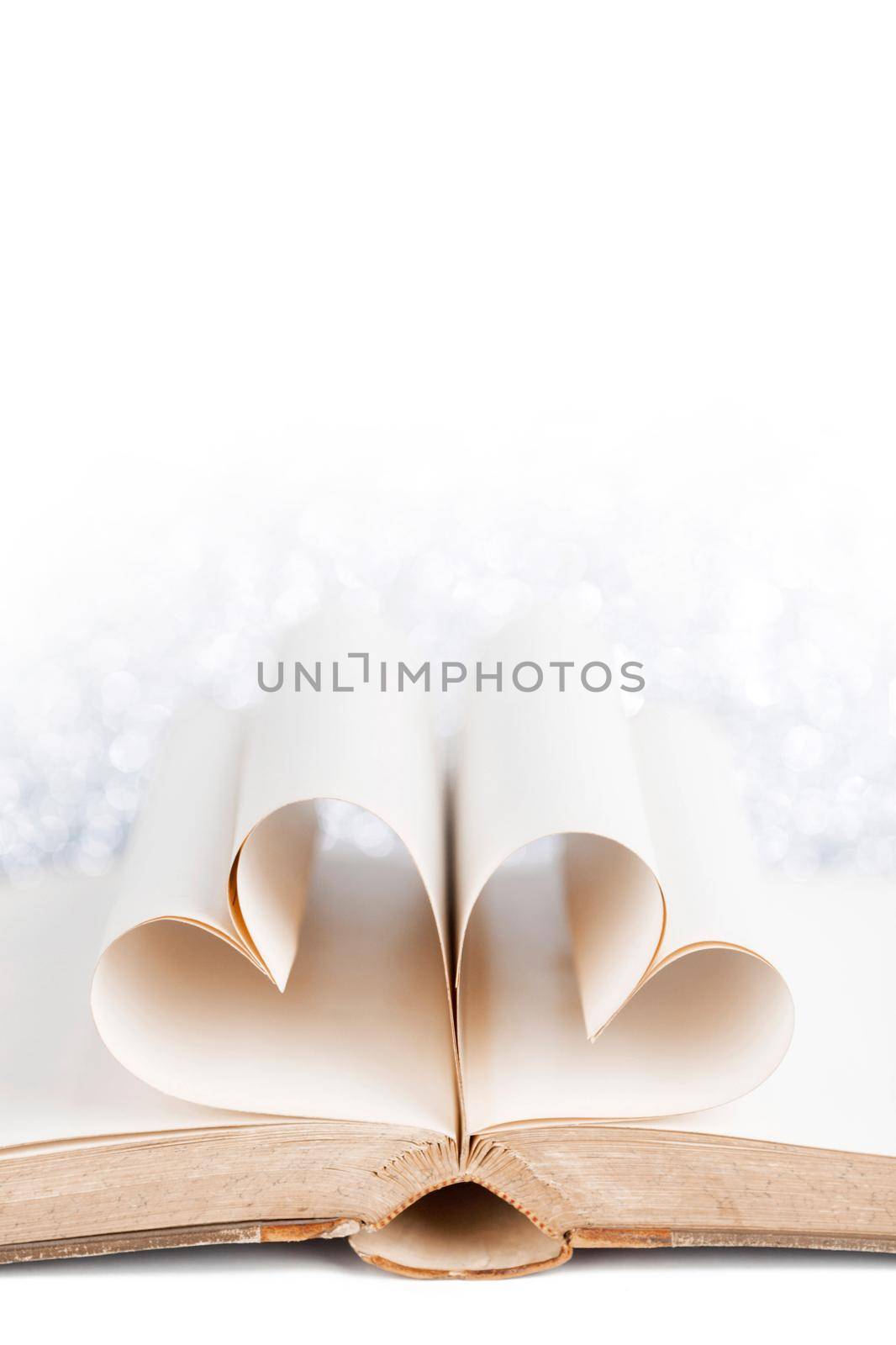 Pages of a book curved into a heart shape on white background, love reading Valentine day