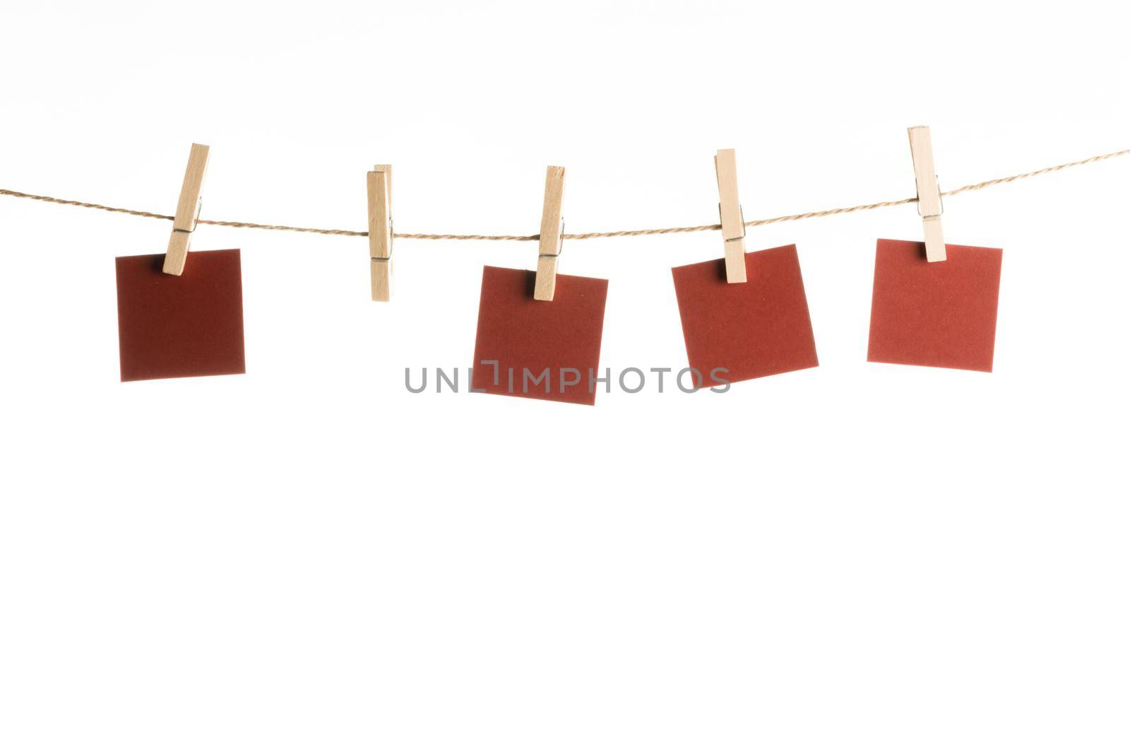 4 Note paper cards hanging with wooden clip or clothespin on rope string peg isolated on white, copy space for I love you
