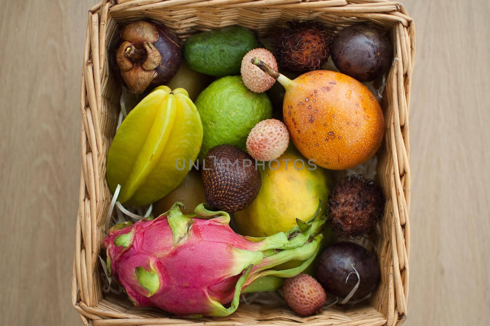 Big basket of fresh tropical fruits, passion fruit, carambola, dragon fruit or pitaya, mangosteen, lichi, granadilla. Exotic fruits, healthy eating concept.