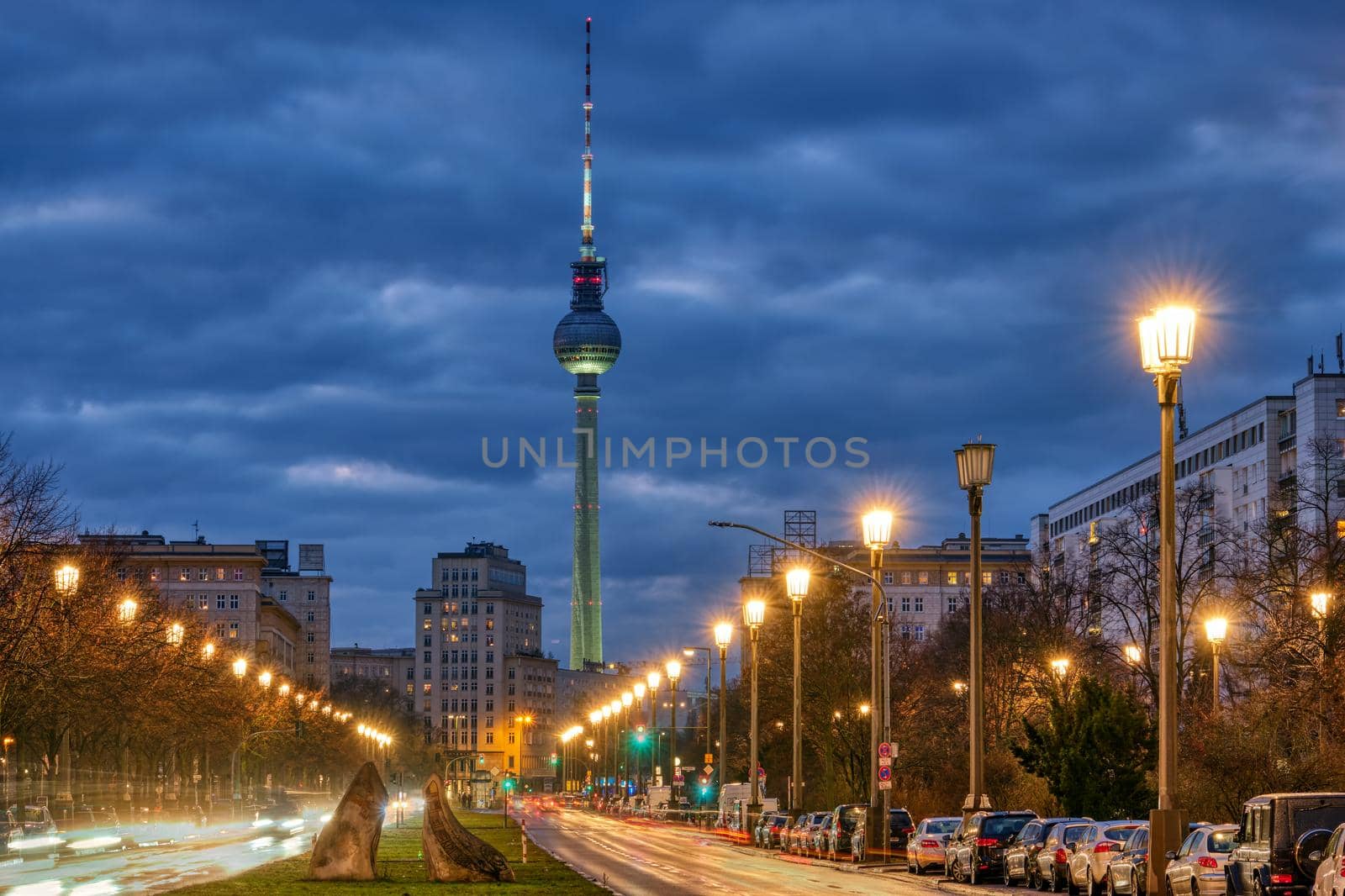 The famous TV Tower of Berlin with one of the big avenues at night