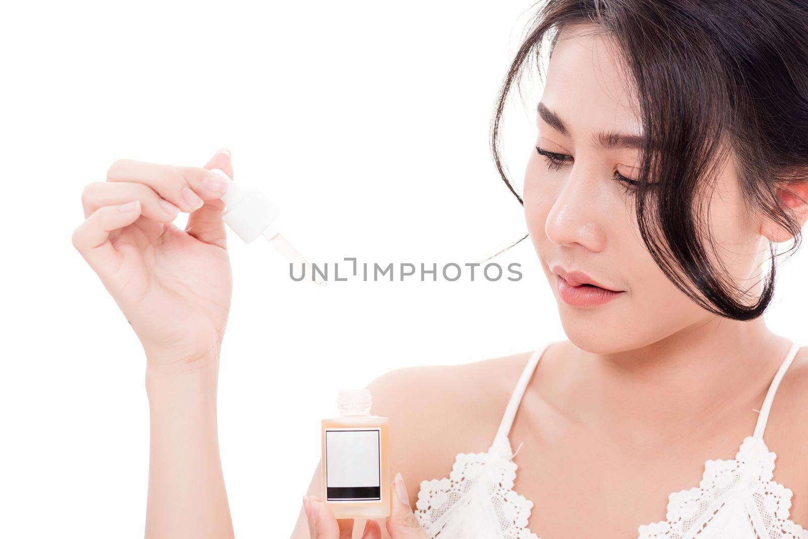 Asian young beautiful woman smiling she's holding bottle serum hair or skin care near face for present product isolated on over white background, Beauty salon concept