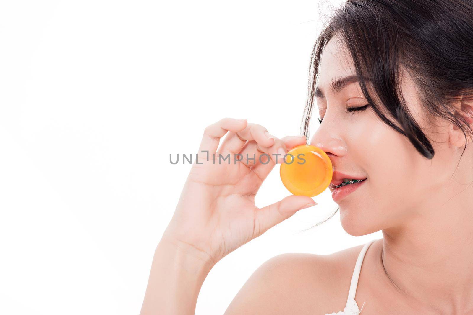 Asian young beautiful woman smiling she's holding orange handcrafted organic soap skin care near face for present product isolated on over white background, Beauty Zero waste concept