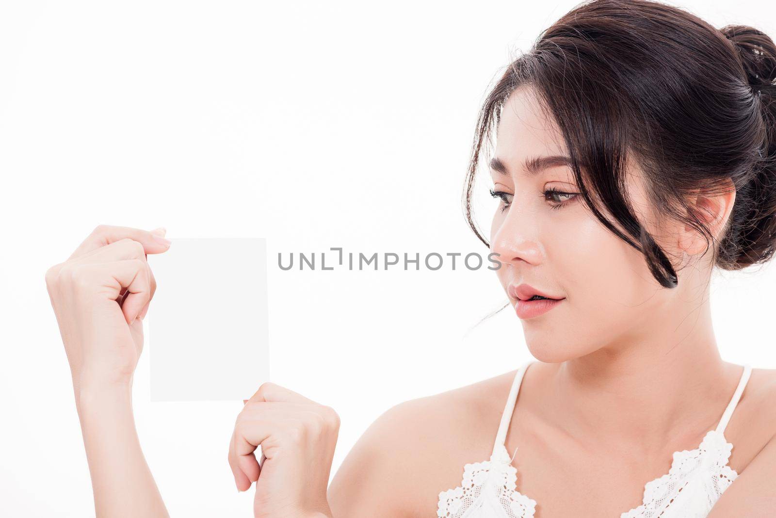 Asian young beautiful woman smiling she's holding blank square skin care near face for present product isolated on over white background, Beauty concept