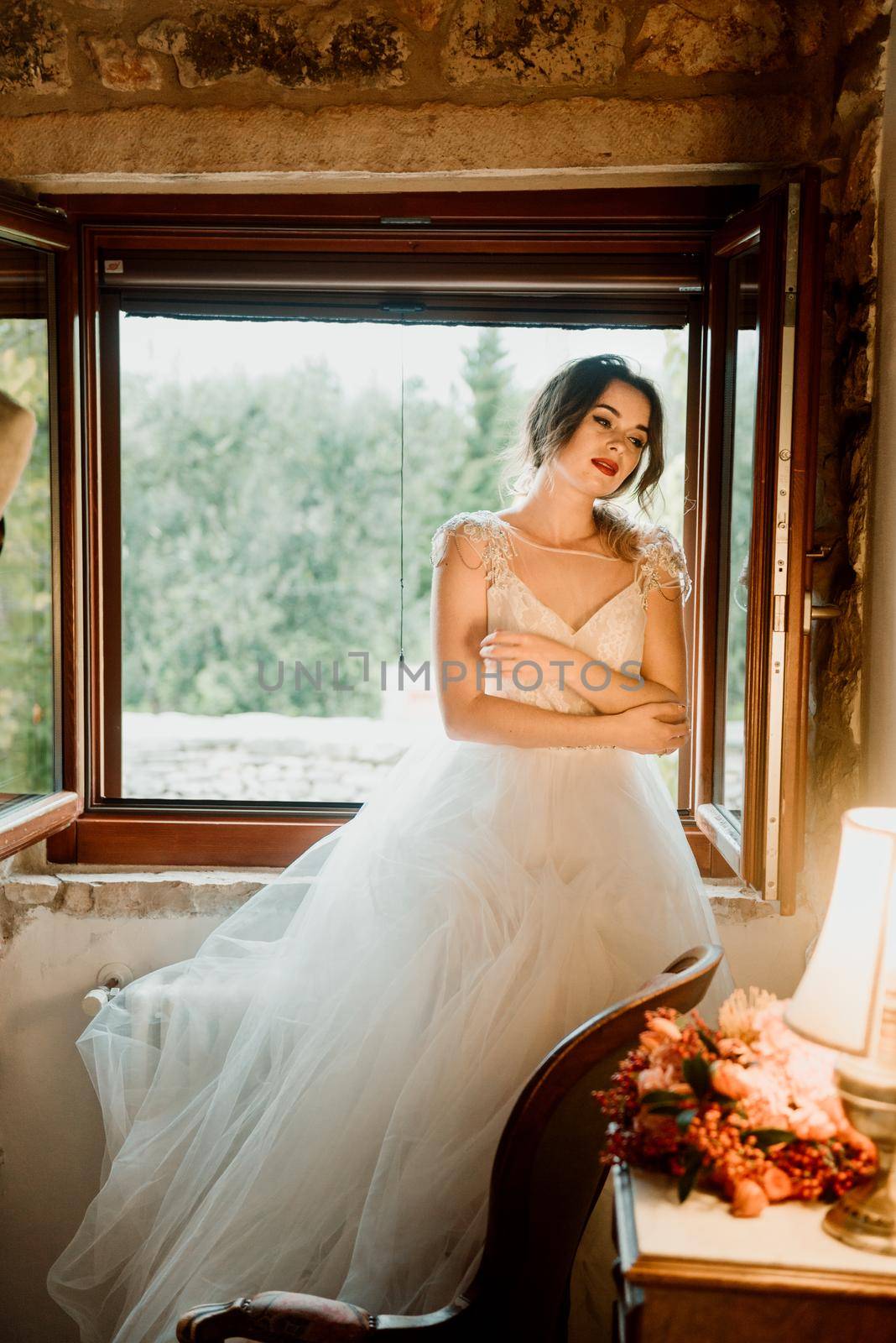 Artistic processing Fantasy girl princess in WHITE WEDDING dress stands in medieval CASTLE room looking vintage window. Bride in a luxury apartment in a wedding dress.. Sweet and gentle girl with fair skin alone in silence in an old castle, spirit of abandoned medieval building by Andrii_Ko