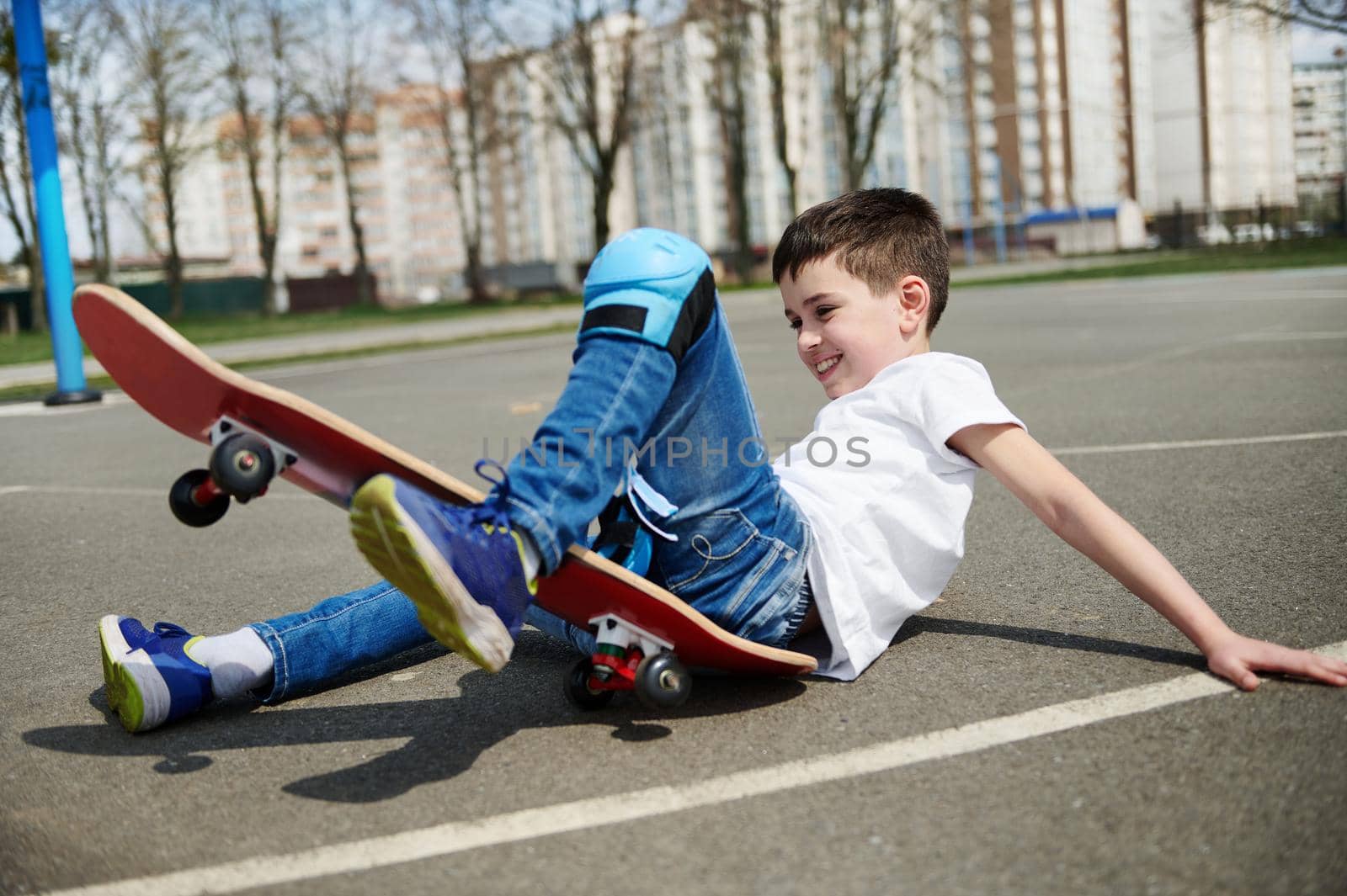 Little boy slipped and fell off the skateboard on the asphalt of the playground by artgf