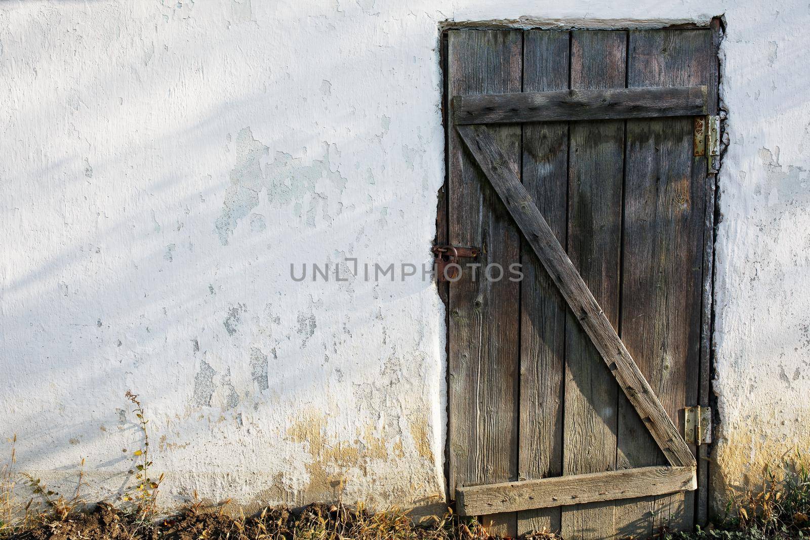 Old wooden door in an old stone wall with a castle