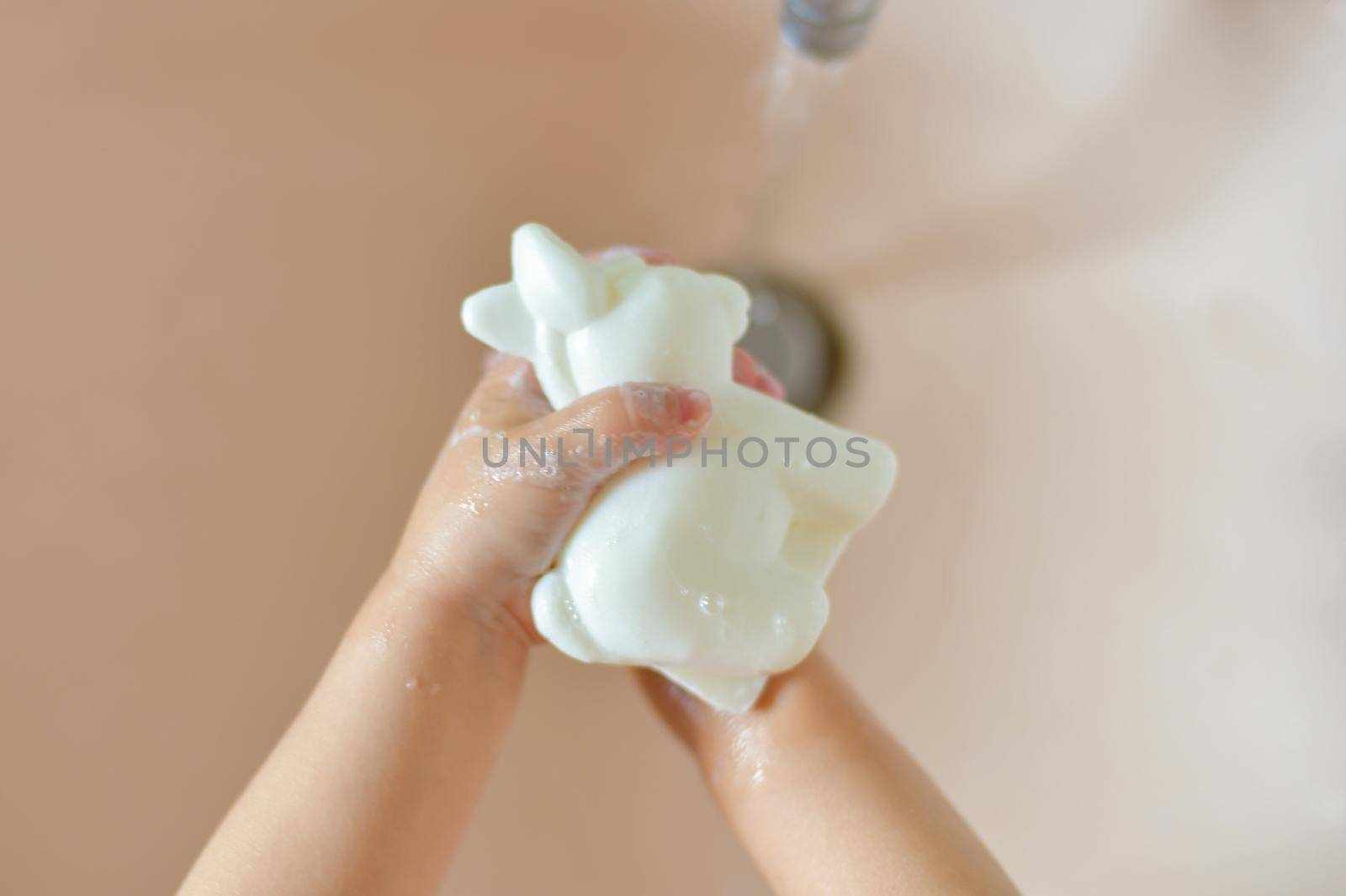 A child washes his hands with soap at home