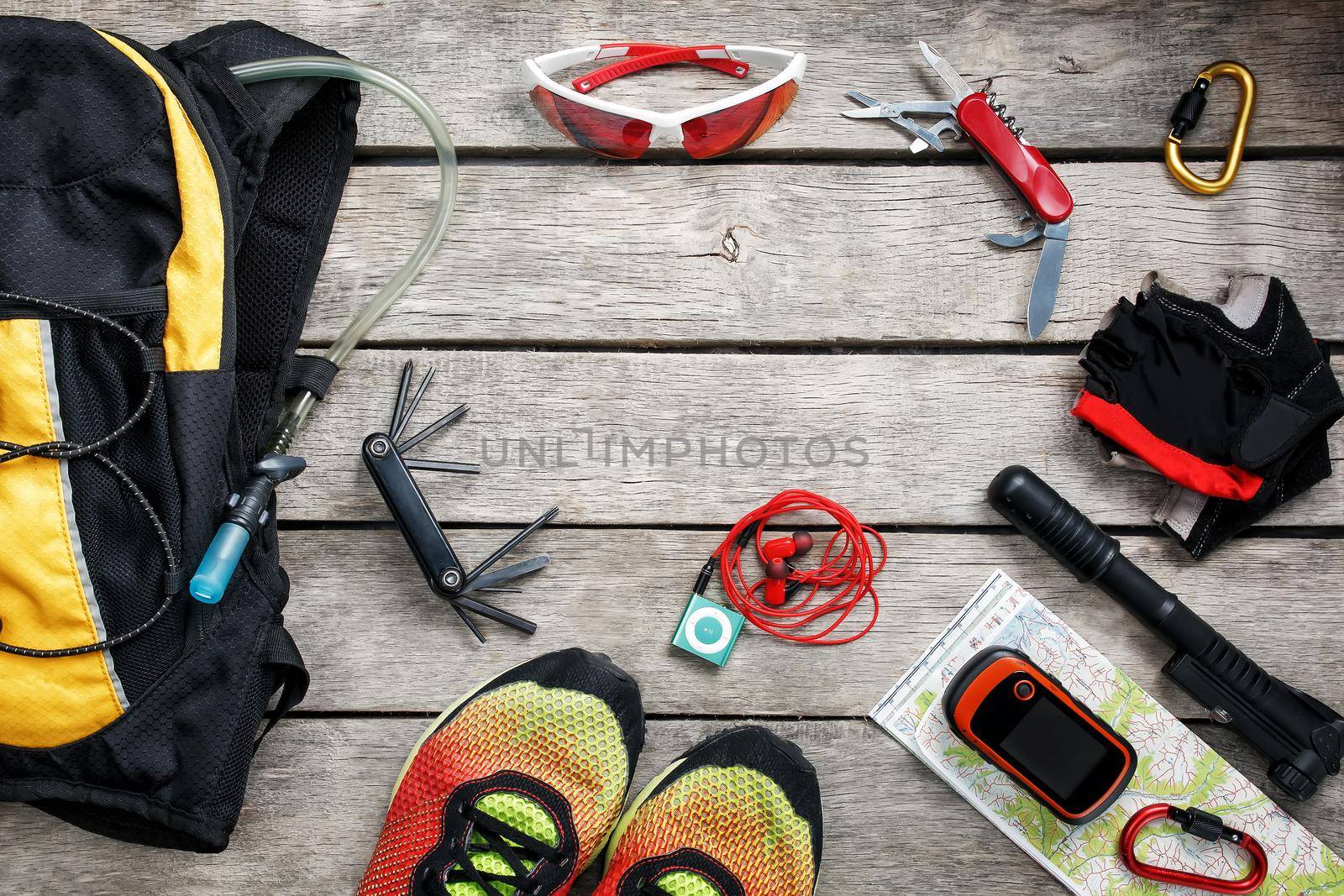 A set of accessories for cycling on a wooden background, With empty space and a notepad in the middle.