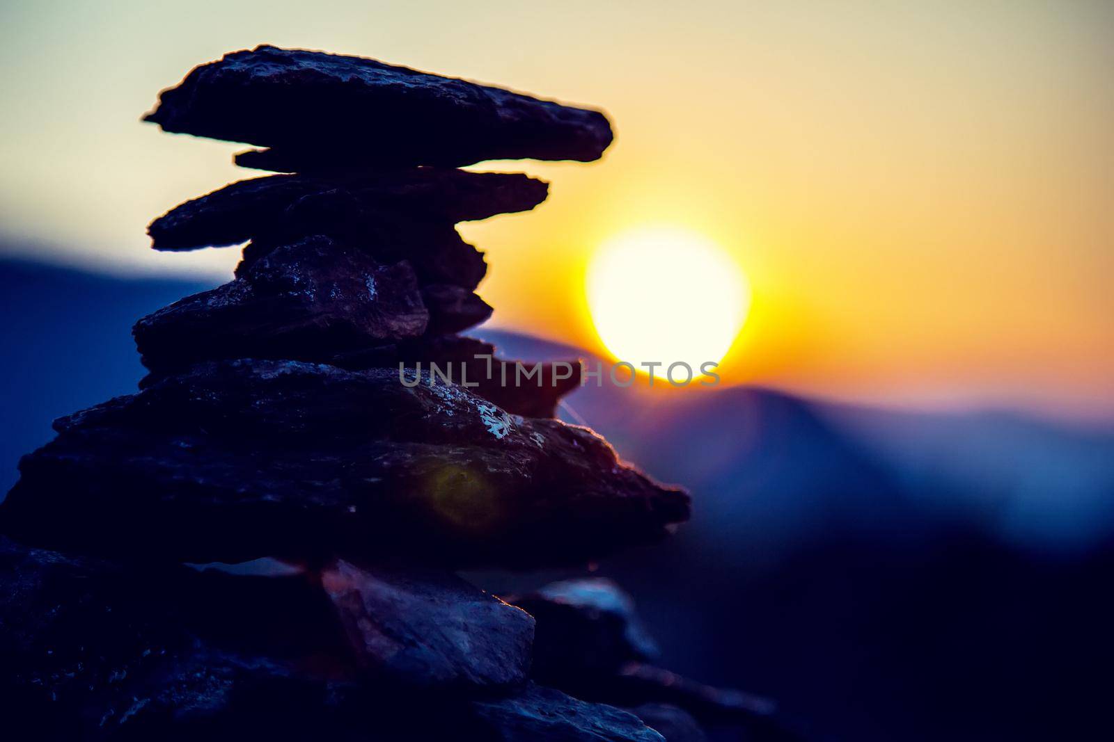 Spa stones balance, colorful summer sky background, silhouette of stacked pebbles and butterfly, beautiful nature, peaceful beach sunset, conceptual image of stable life by AlexGrec