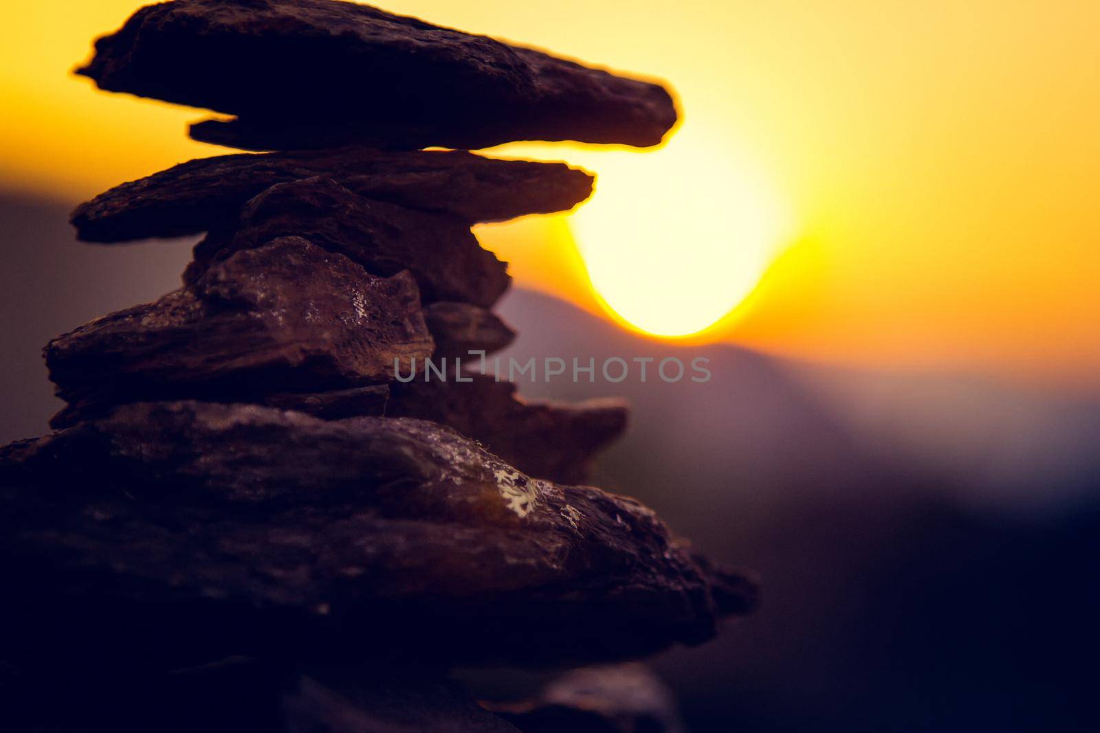 Spa stones balance, colorful summer sky background, silhouette of stacked pebbles and butterfly, beautiful nature, peaceful beach sunset, conceptual image of stable life and harmony