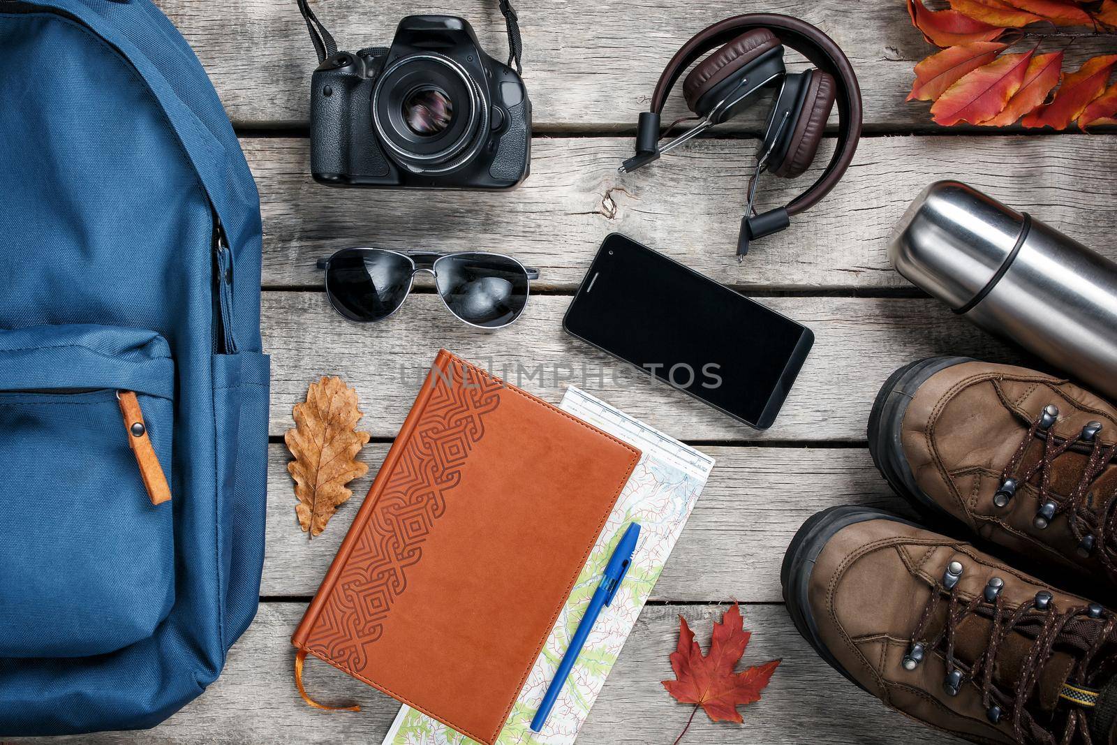 A set of materials for travel on a wooden background, notepad. Empty space in the middle.