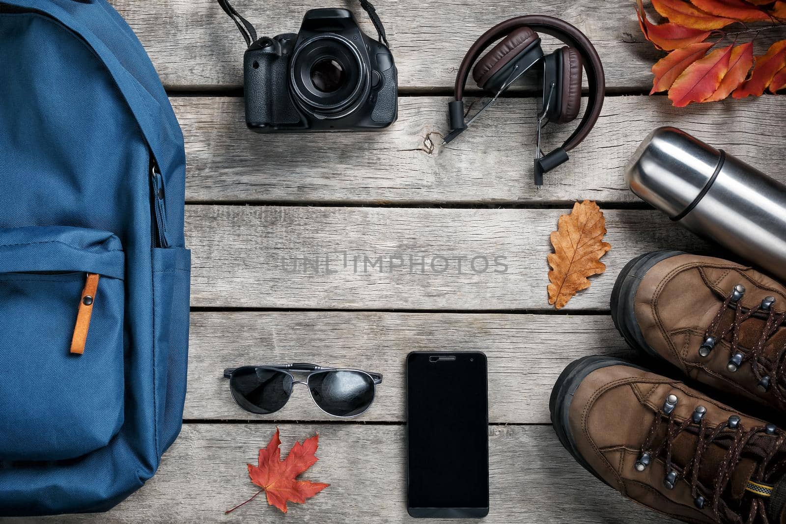 A set of materials for travel on a wooden background, notepad. Empty space in the middle.