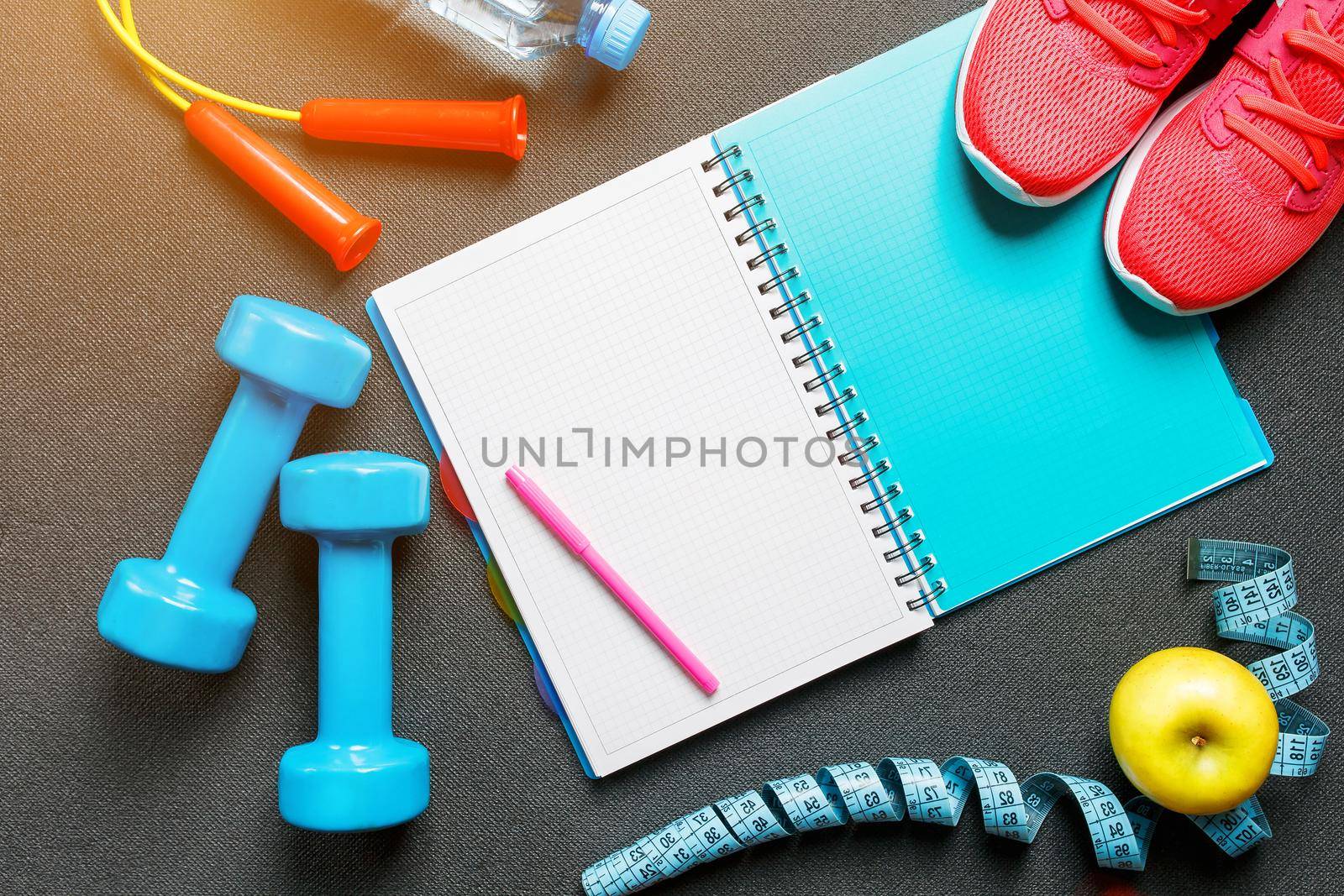 Set of sports accessories for fitness concept with exercise equipment on gray background. Background view from above