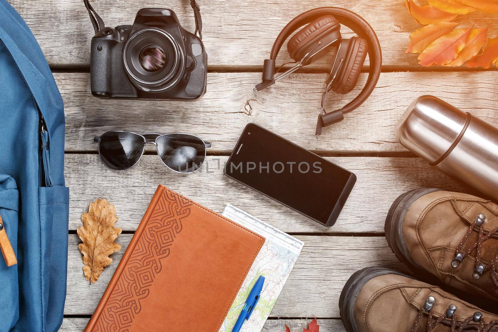 Set of things and tourist equipment for travel and adventure on a gray wooden background. Top view set by AlexGrec
