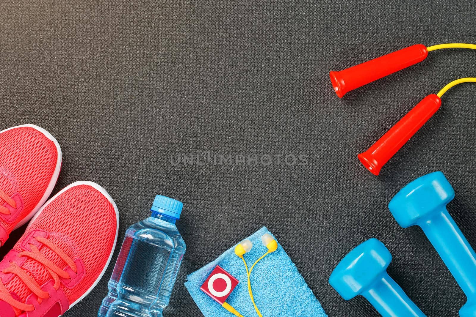 Set of sports accessories for fitness concept with exercise equipment on gray background. Background view from above