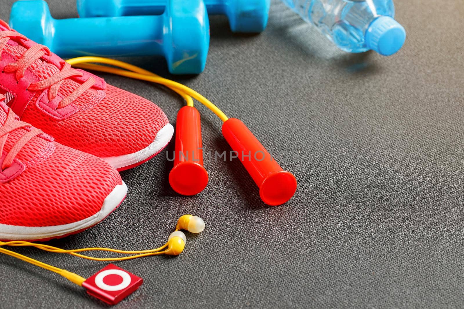 Set of sports accessories for fitness concept with exercise equipment on gray background. Background view from above