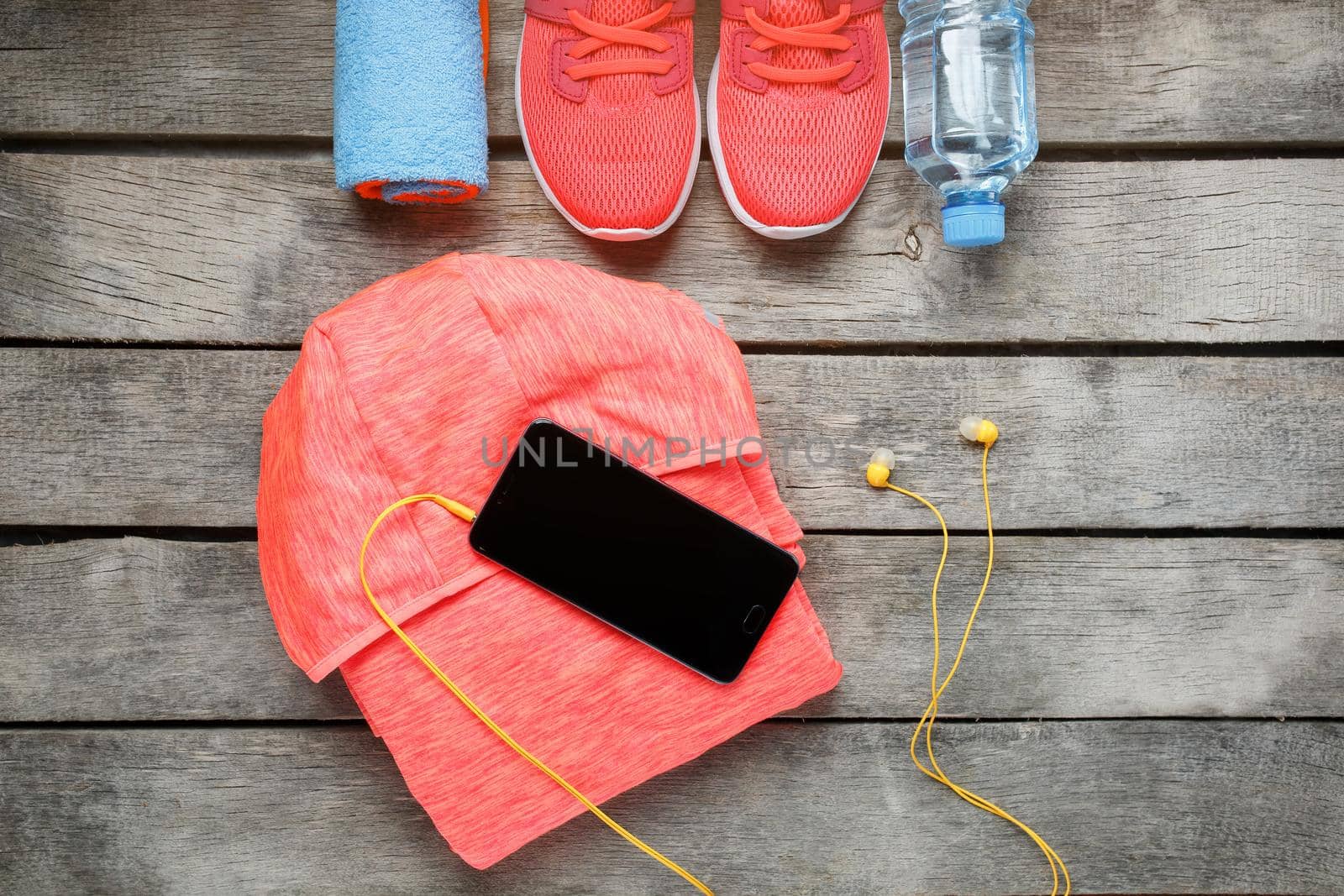 Sports equipment and the smartphone with earphones on a wooden background. Health Fitness
