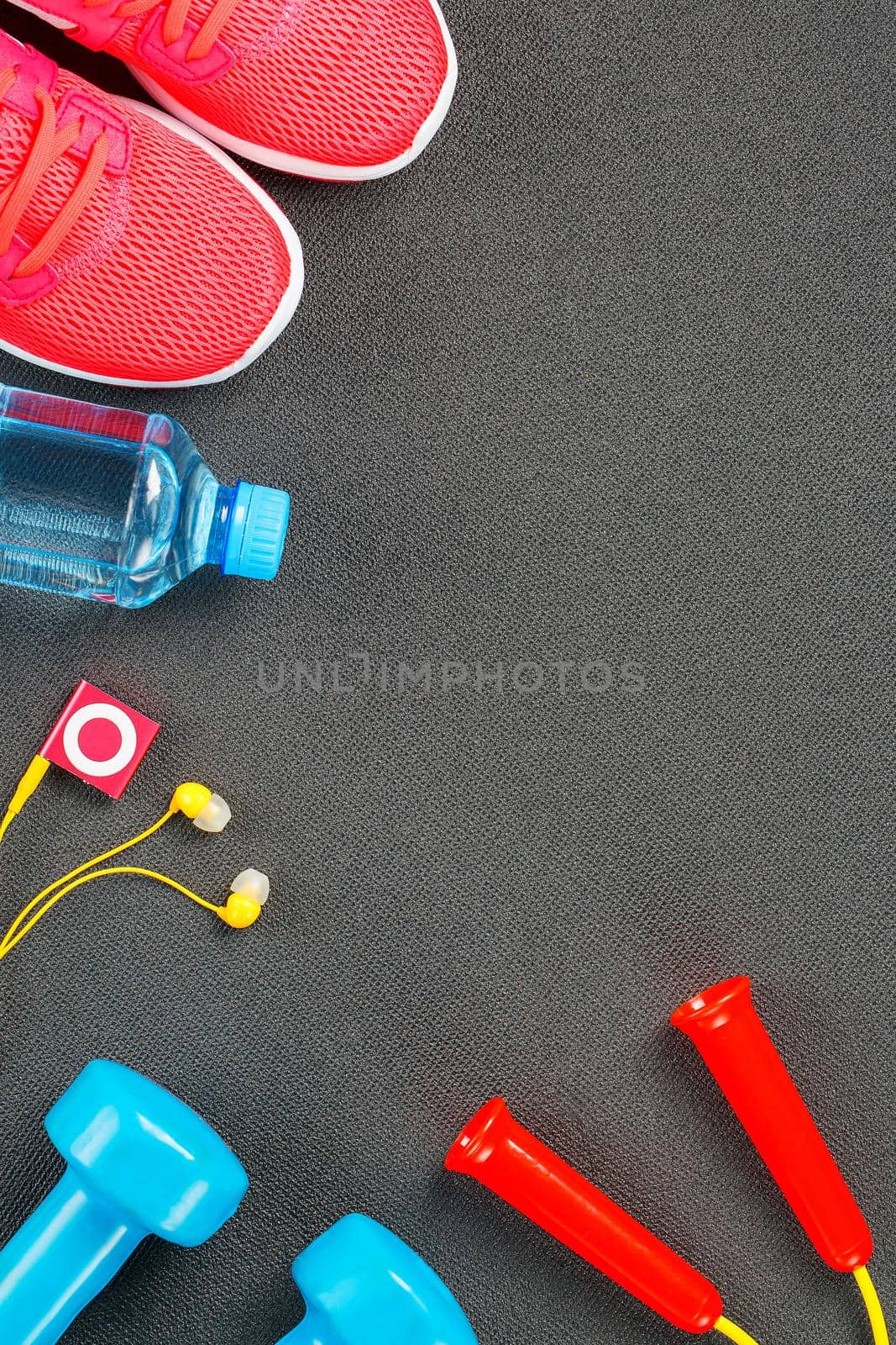 Set of sports accessories for fitness concept with exercise equipment on gray background. Background view from above
