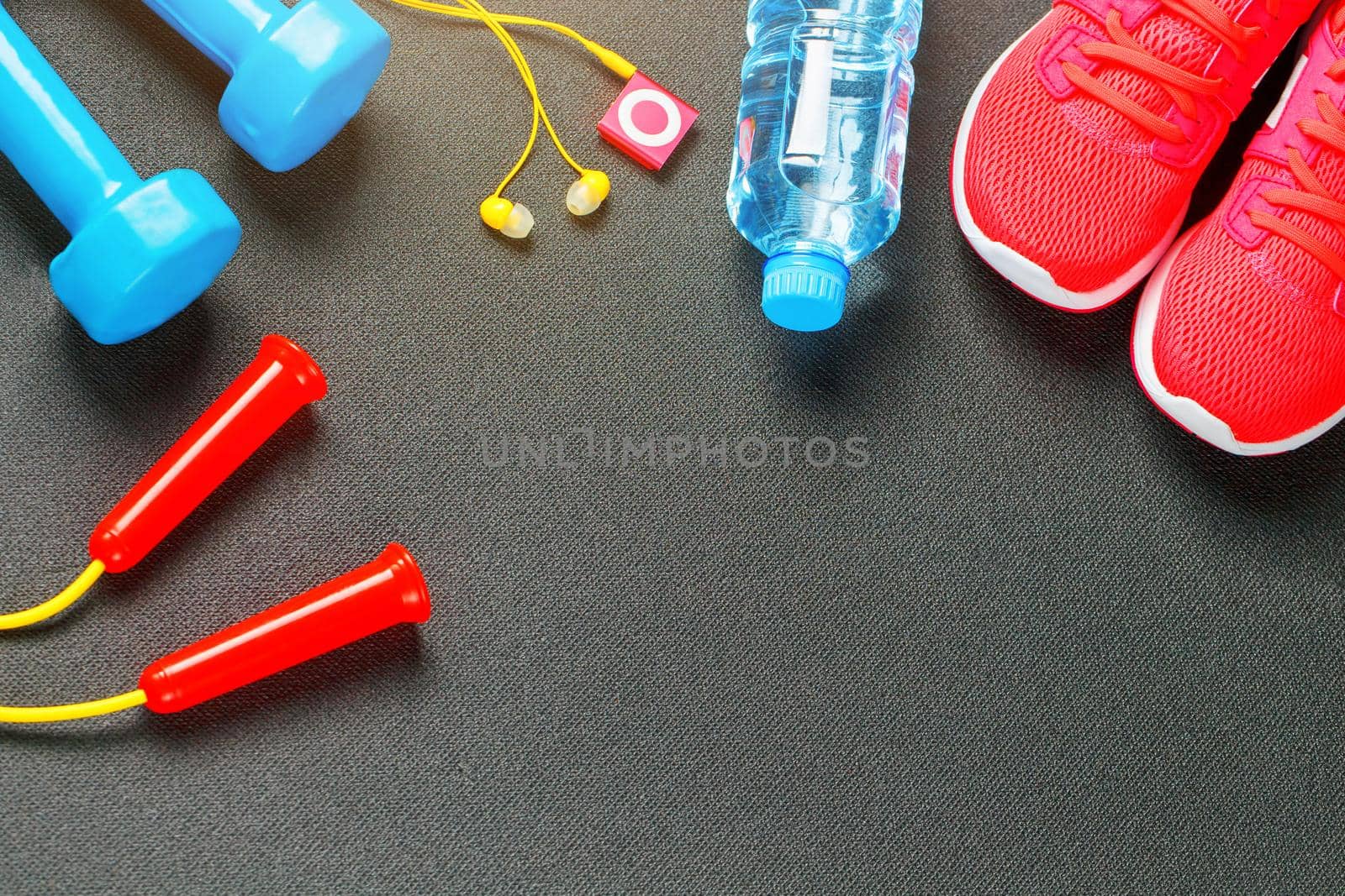 Set of sports accessories for fitness concept with exercise equipment on gray background. Background view from above