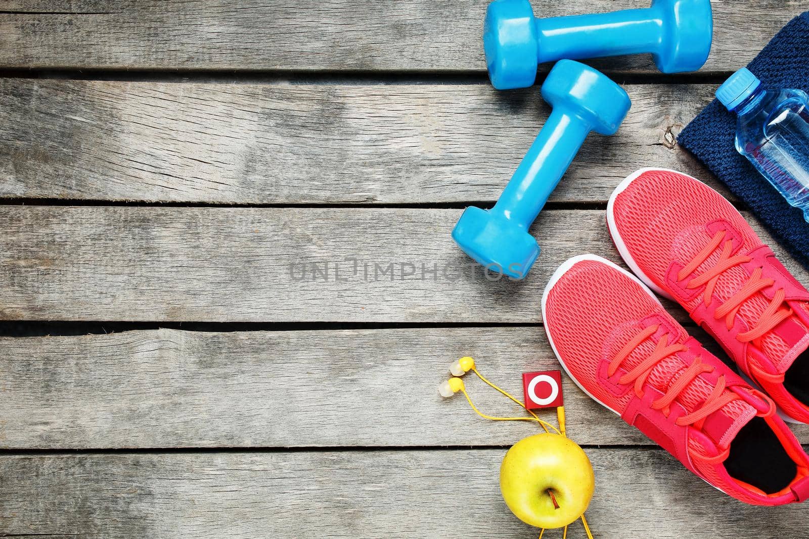 Set of sports accessories for fitness concept with exercise equipment on gray wooden background. by AlexGrec
