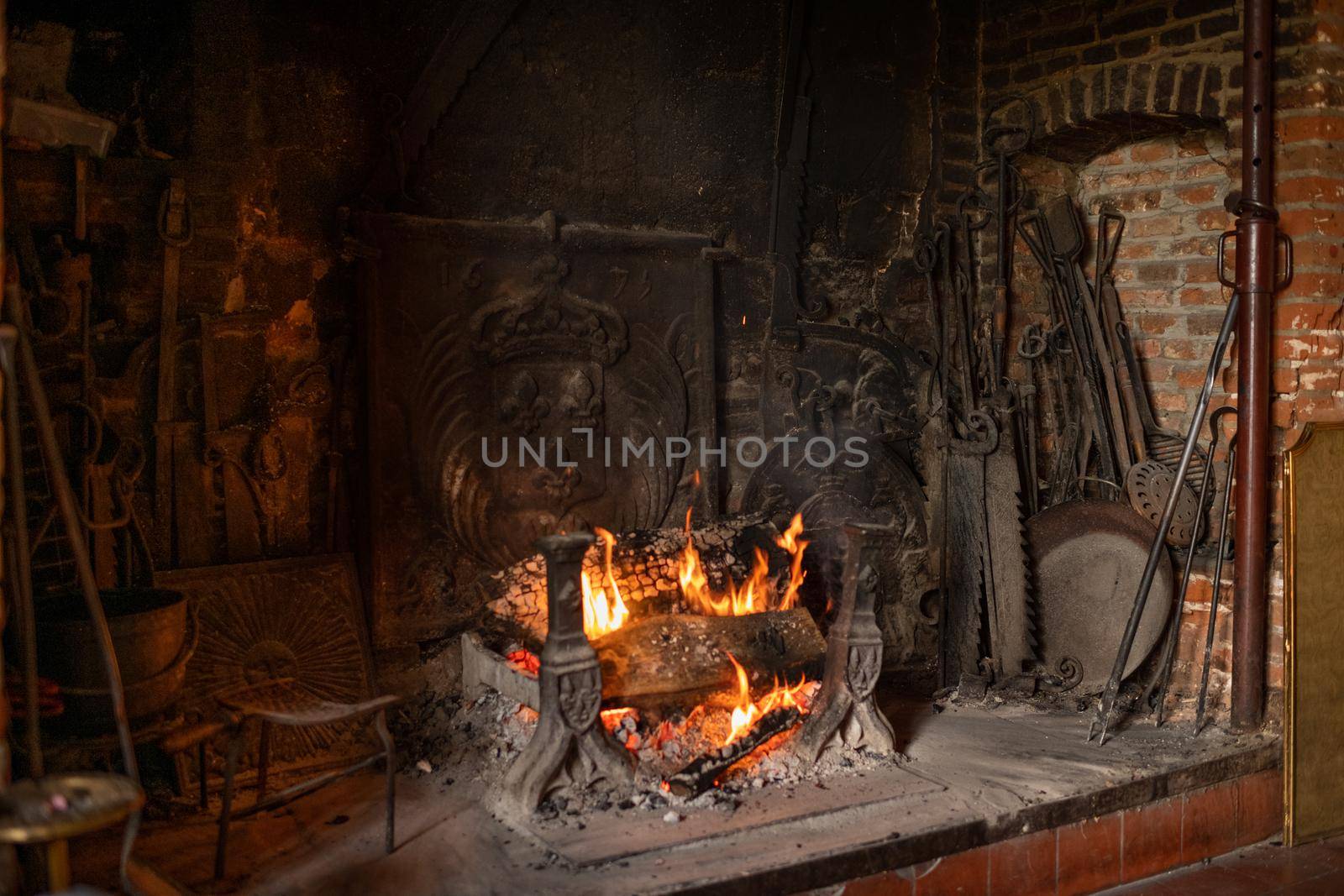 Fireplace and bonfire with firewood in an old French house